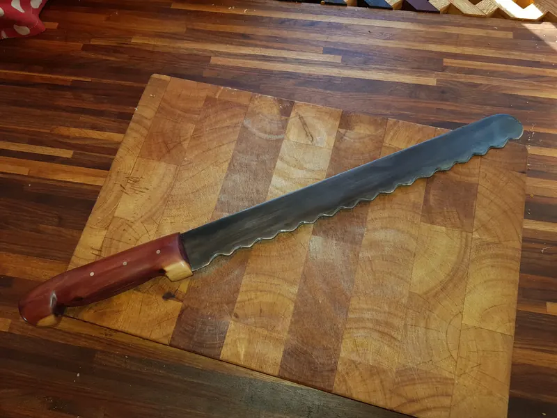 Bread knife with a red wooden handle, finished project