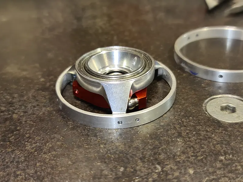 Machined circular assembly with its bearing and red inner housing